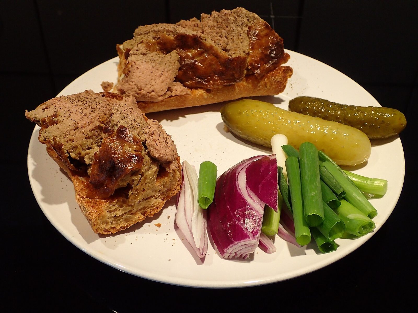 Paté de hígado danés sobre pan con pepinillos, cebolla morada y cebolleta