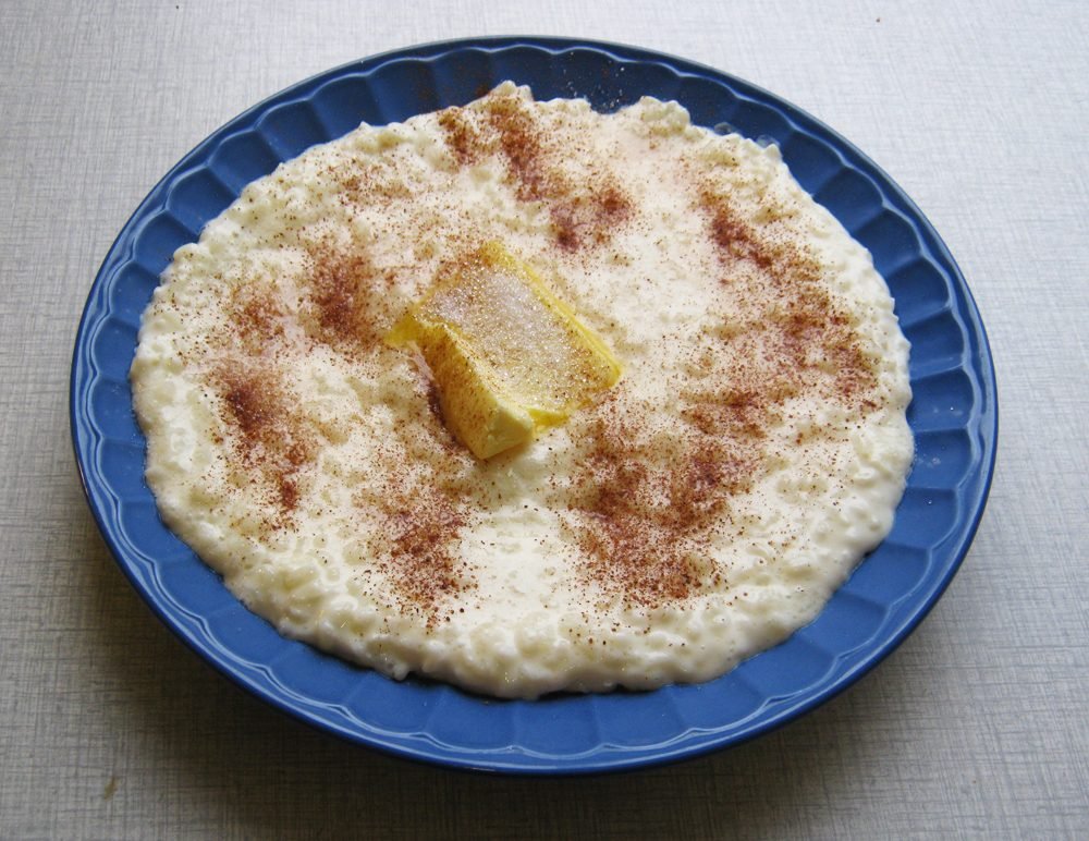 Piatto di riso al latte con un pezzetto di burro e cannella